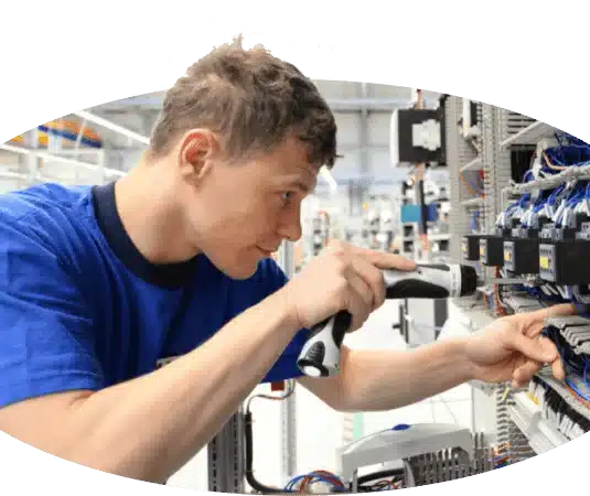 A handwerker stellen jobs on a machine in a factory.