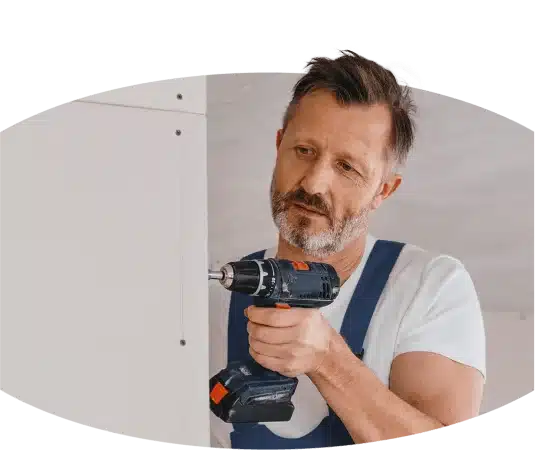 Ein Berufs, der eine Bohrmaschine in der Hand hält.