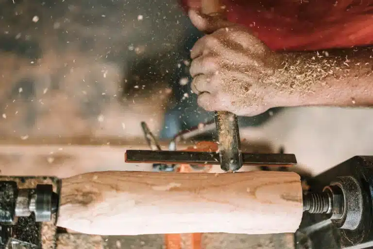 A handwerker is working on a wood lathe.